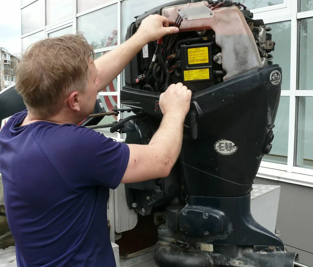 Technician working on boat engine at dock