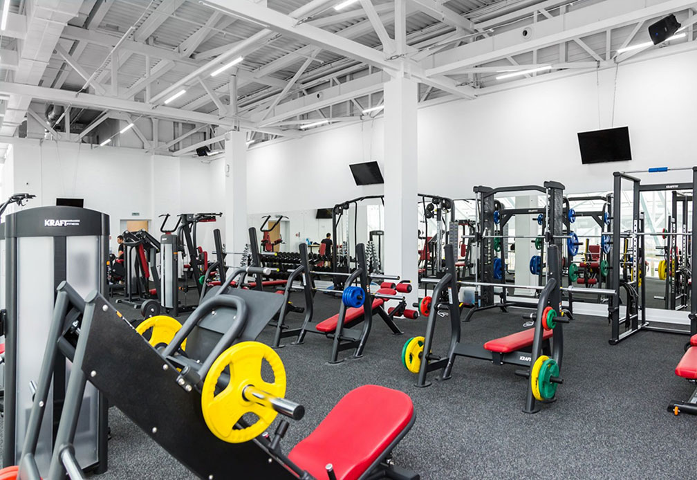 Personal trainer working with client in modern gym