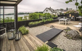 Modern rooftop service area with planters and dining space